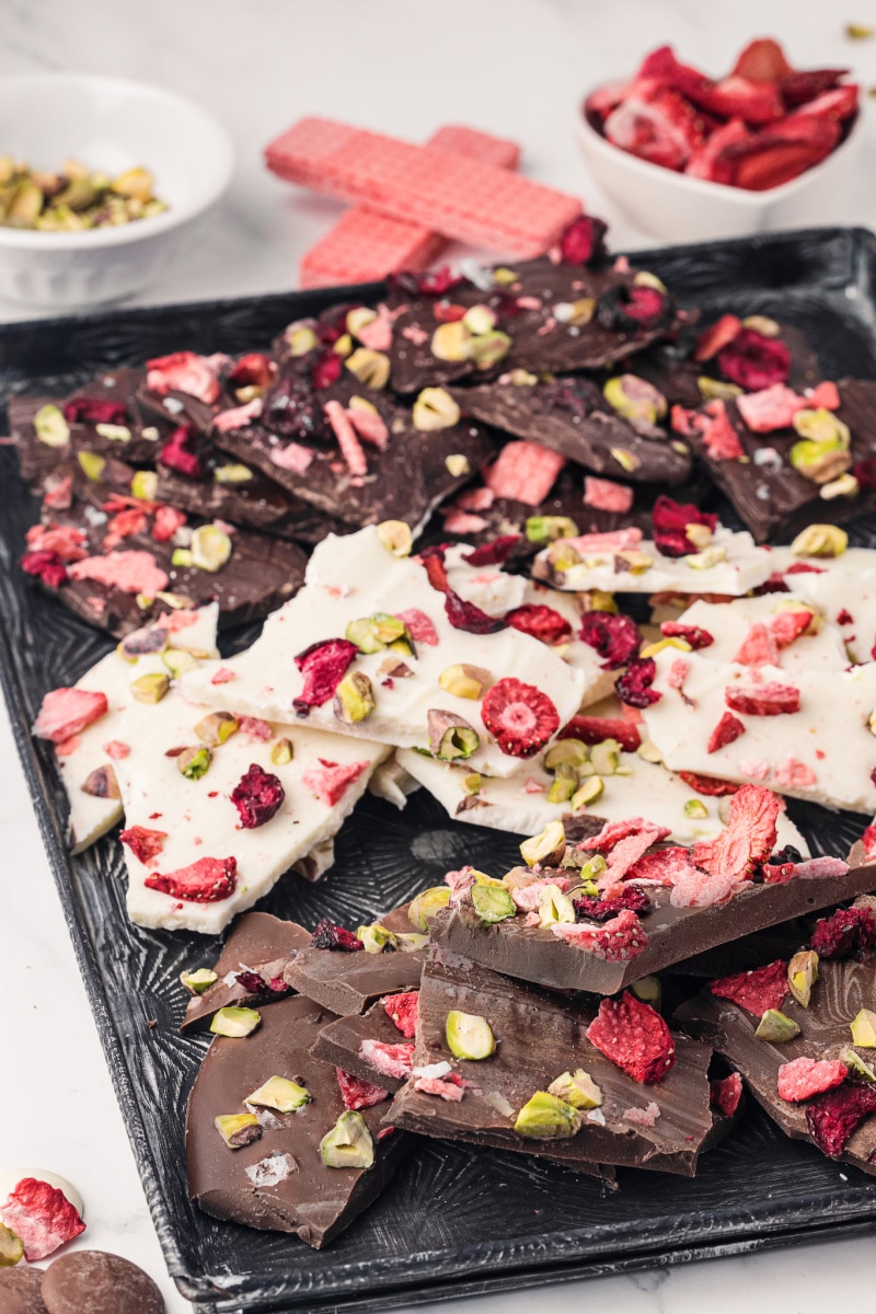 Tray full of white and dark chocolate candy bark with dried fruit toppings