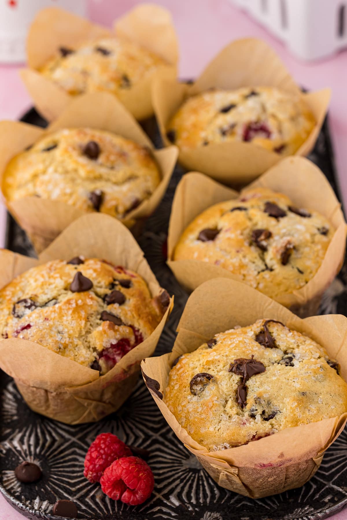 6 chocolate chip muffins wrapped in parchment paper sitting on a pretty tray