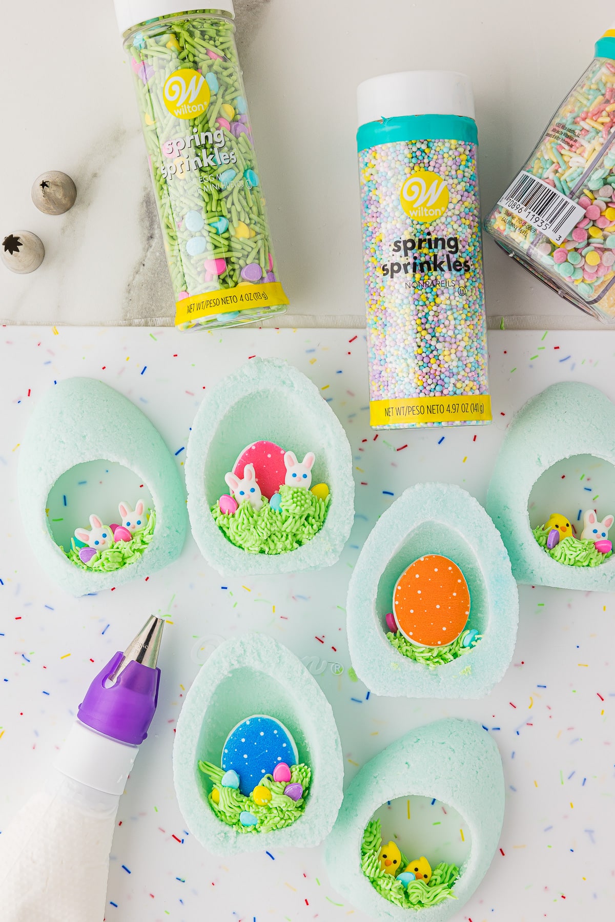 Several carved out sugar Easter eggs with sprinkles and candy decorations