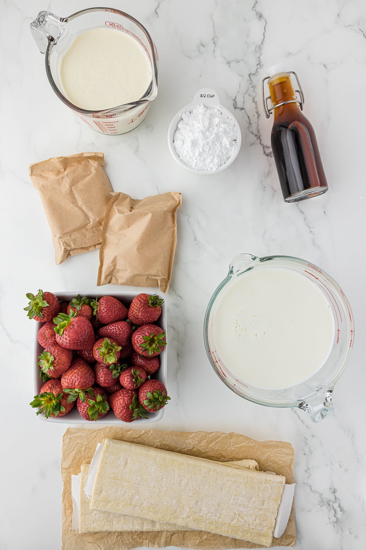 Ingredients for making Strawberry Napoleons all laid out on a white marble countertop