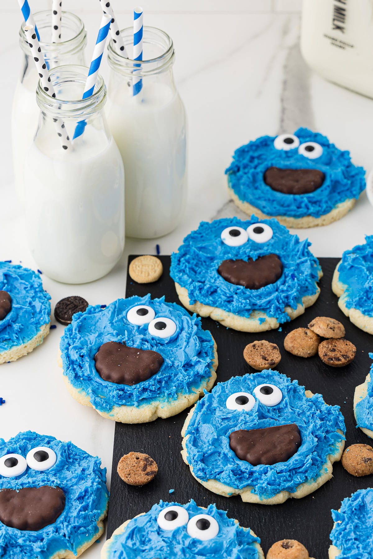 cookie monster cookies on a counter with mini cookies and milk