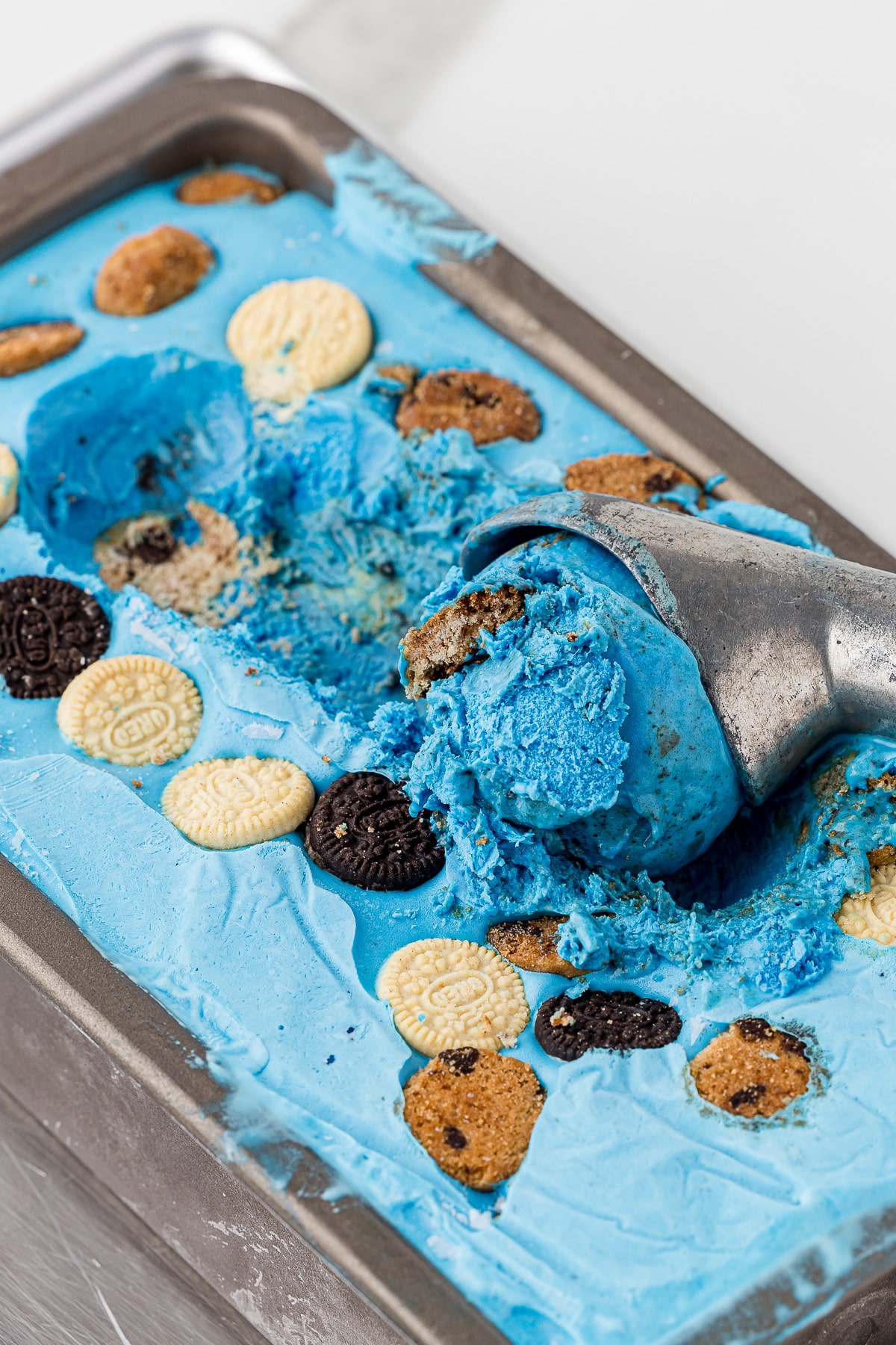Frozen blue ice cream with mini chocolate chip and oreo cookies mixed in to make cookie monster ice cream that is blue and delicious