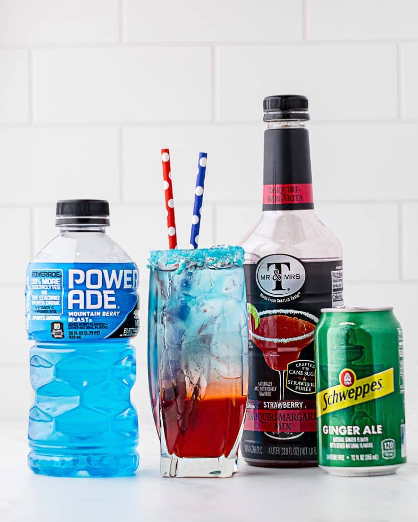 Drink in a tall thin glass with 3 different layers of color: red, white and blue; and including containers of red daquiri margarita mix, clear ginger ale, and blue powerade