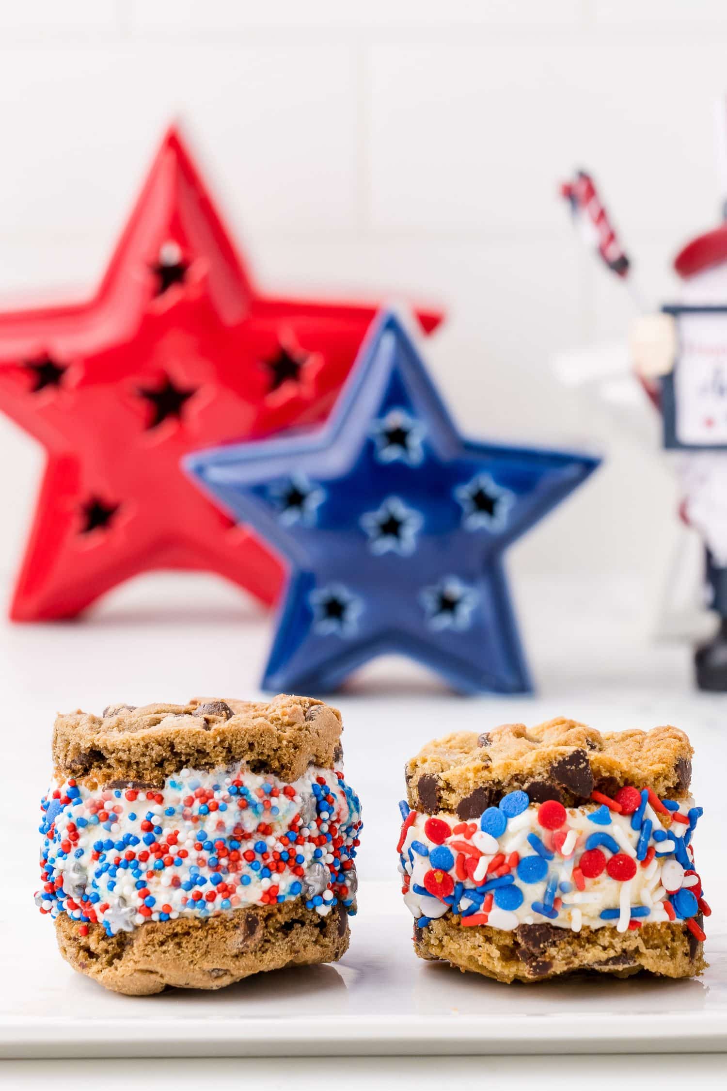 two 4th of July sandwich cookies on a white serving plate with a red, a blue, and a white star in the background