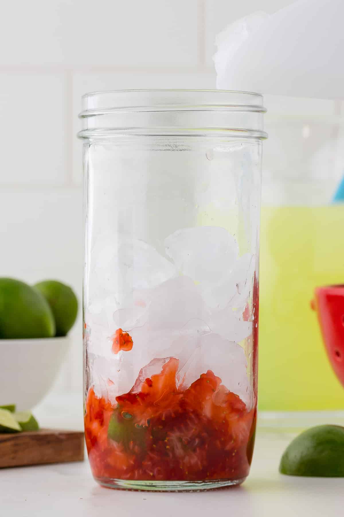 Strawberry puree and ice in a clear glass drinking cup