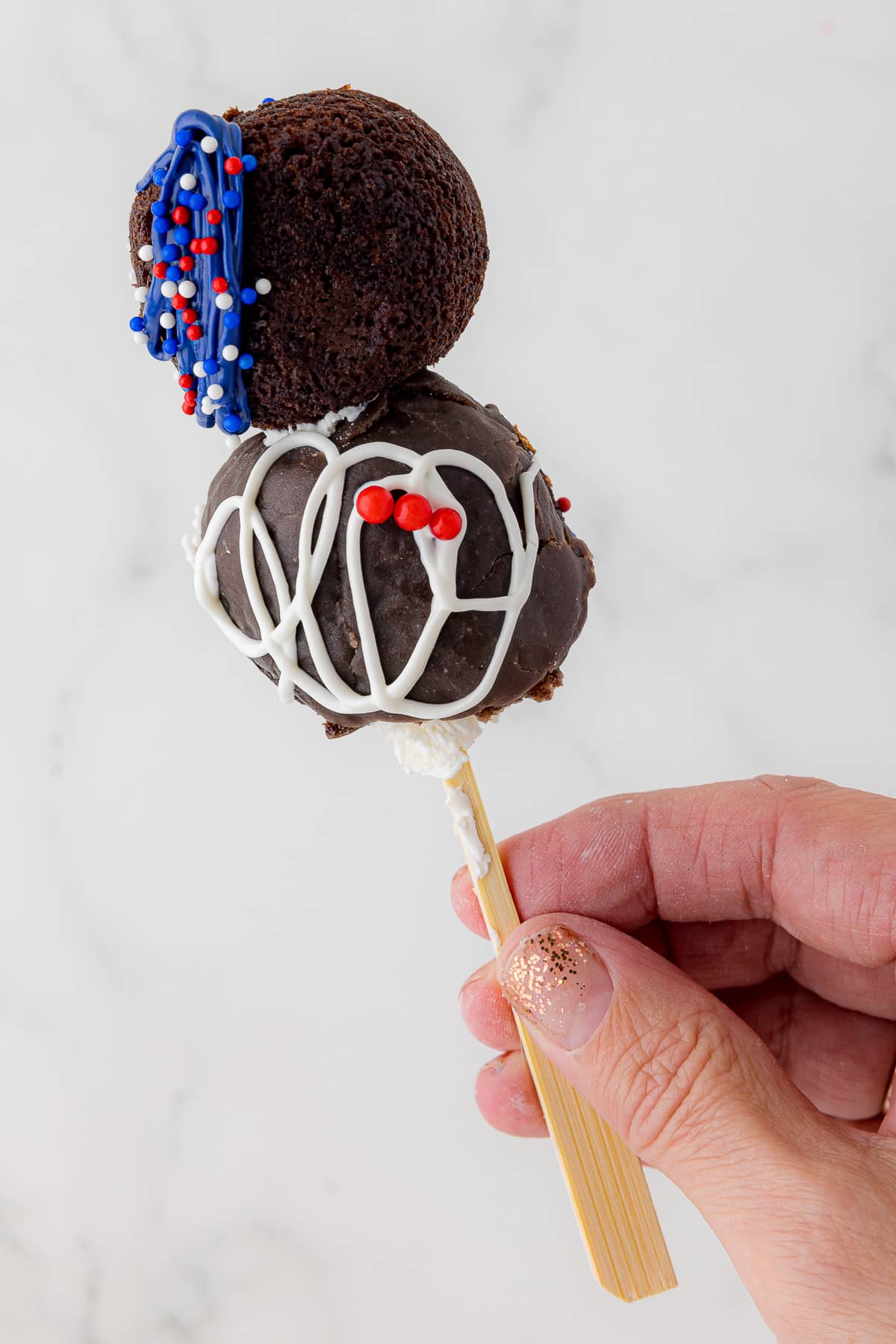 two hostess bouncers on a skewer decorated with red white and blue melted chocolate.