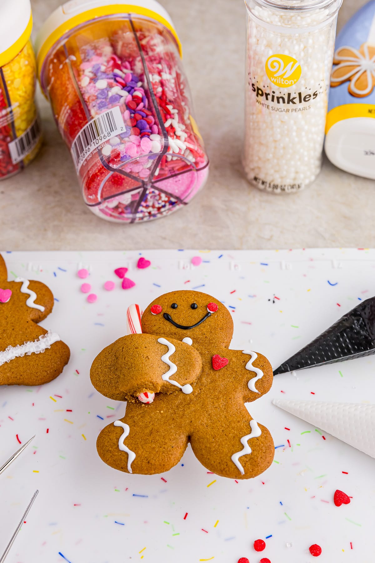 decorated gingerbread man with frosting and sprinkles in the background
