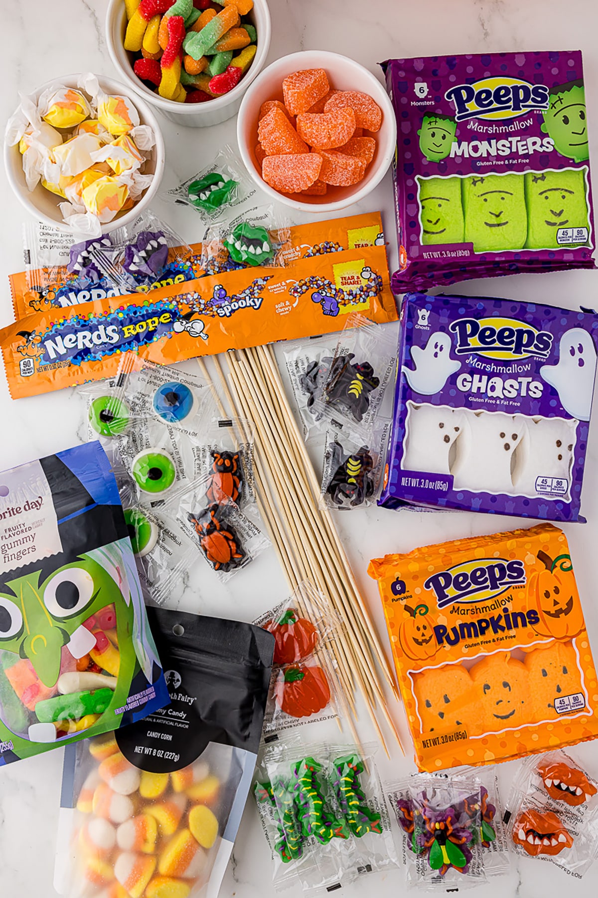 ingredients for candy kabobs including halloween peeps, wooden skewers, and gummy candies