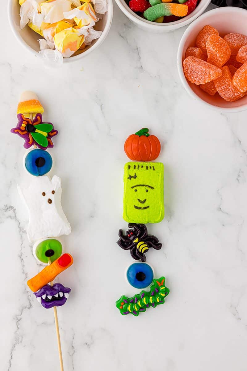 candy skewer, three bowls of jelly candies, and the fifth candy, a catepillar under the pumpkin, frankenstein, spider, and eyeball