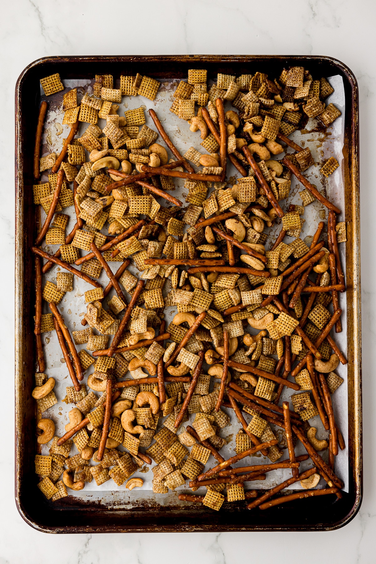 baked chex mix on a cookie sheet lined with parchment paper