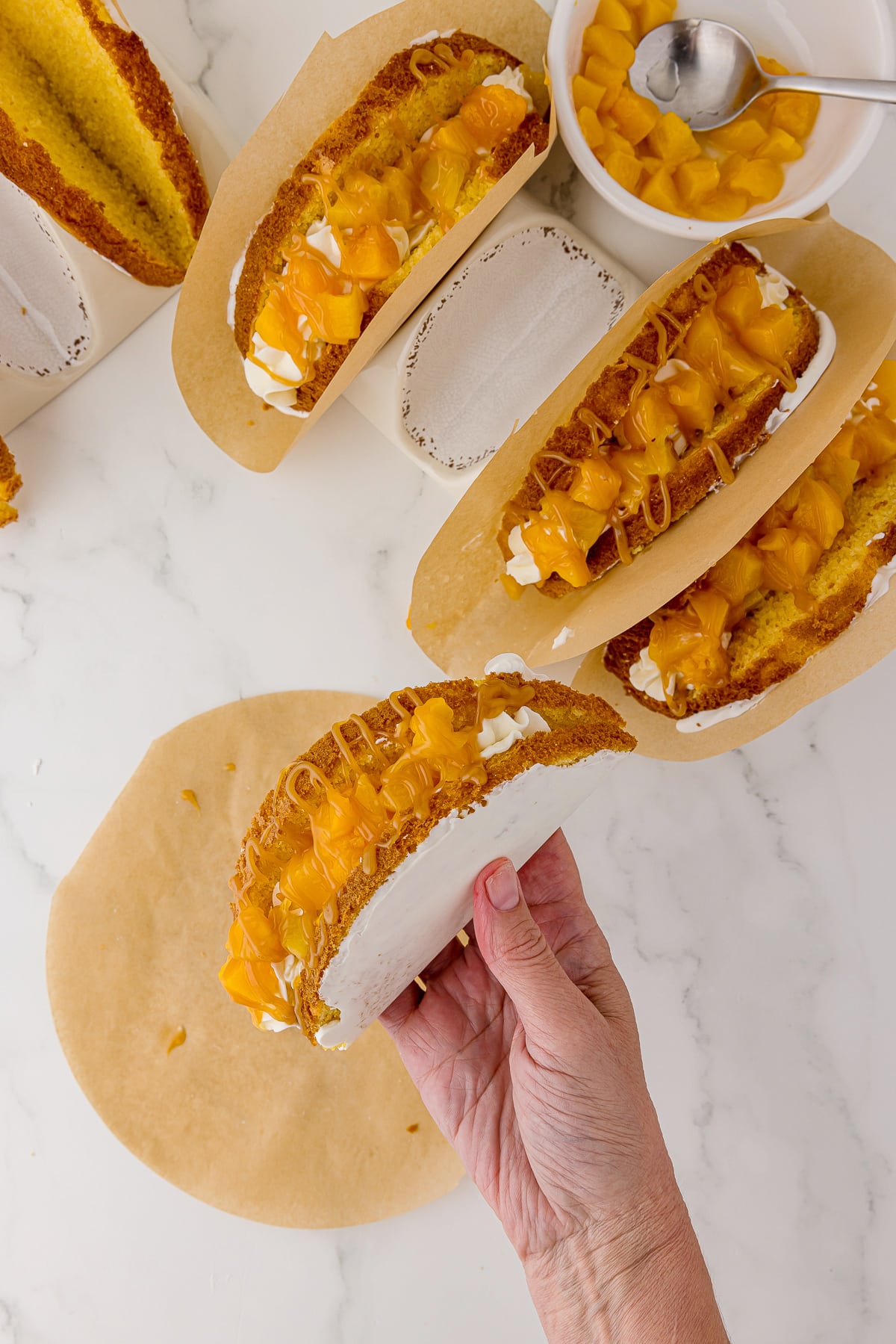 four peach cake tacos on a white marble background