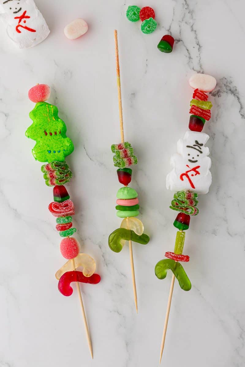 Christmas Candy kabob being put together on a white countertop