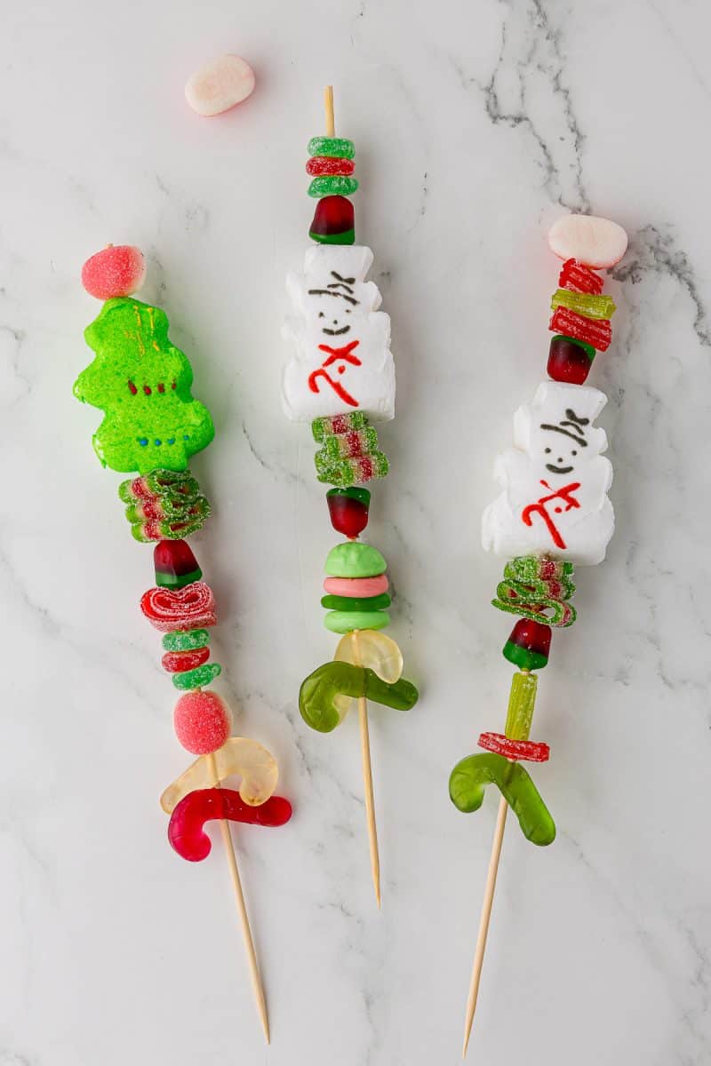 Christmas Candy kabob being put together on a white countertop