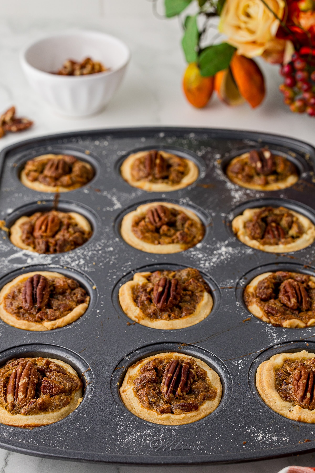 Baked mini pecan pies in a mini muffin pan.