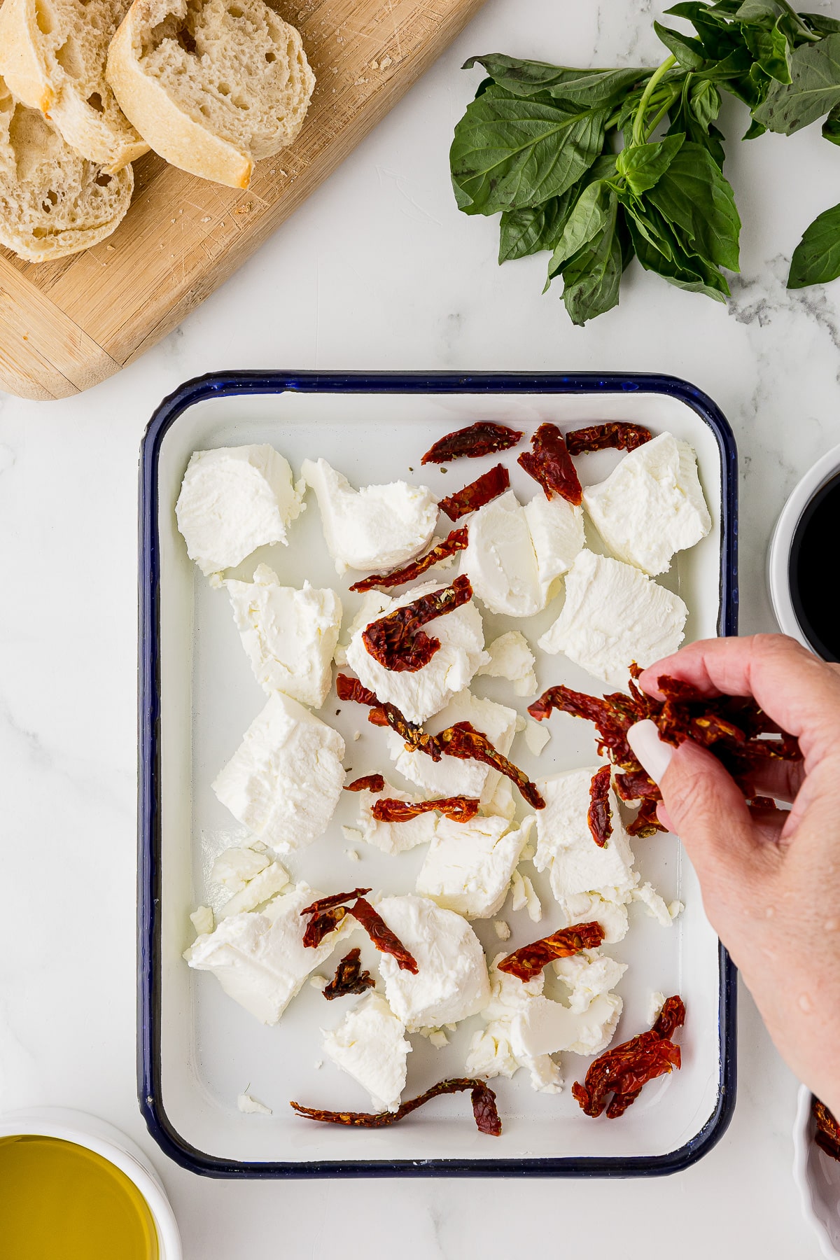 sprinkling sun-dried tomato strips over goat cheese