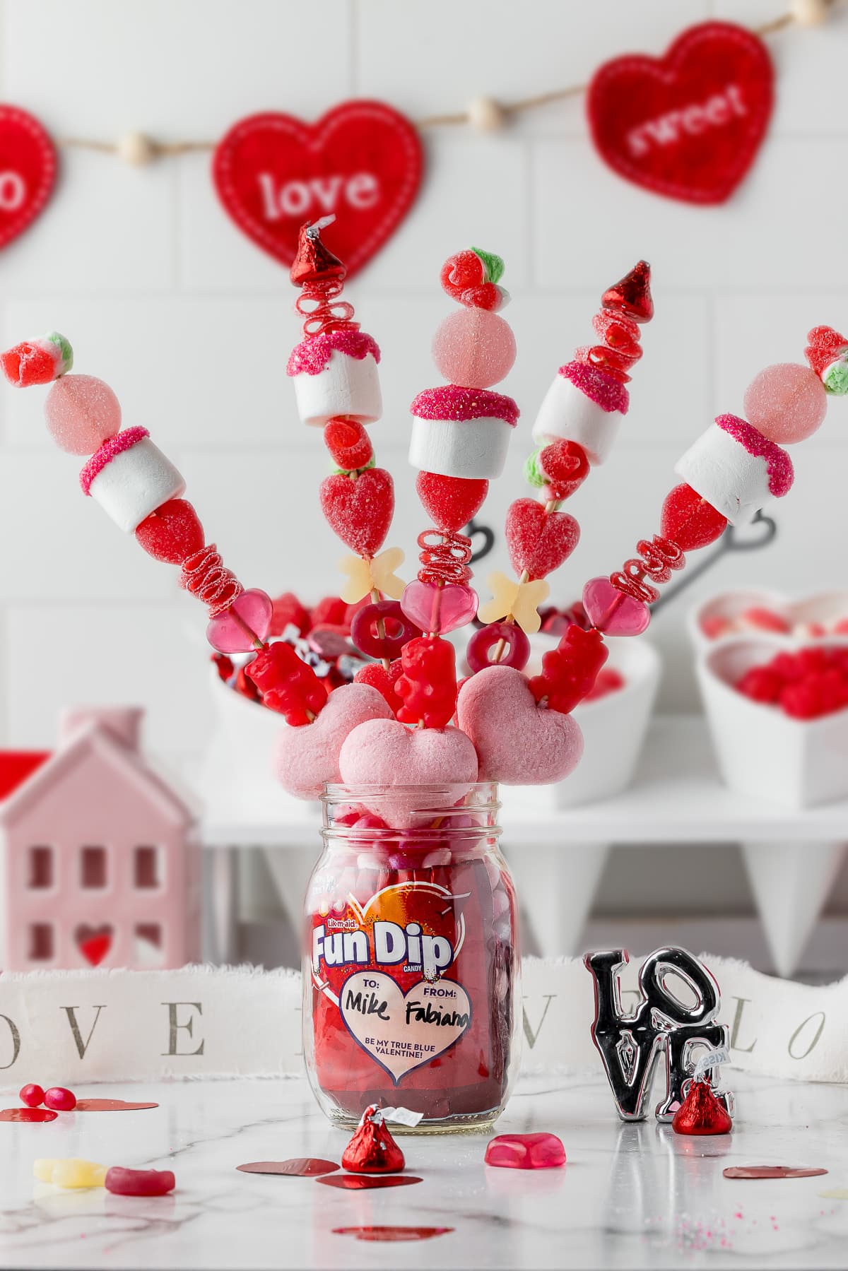 5 valentine's day candy kabobs in a mason jar with fun dip and heart shaped accessories