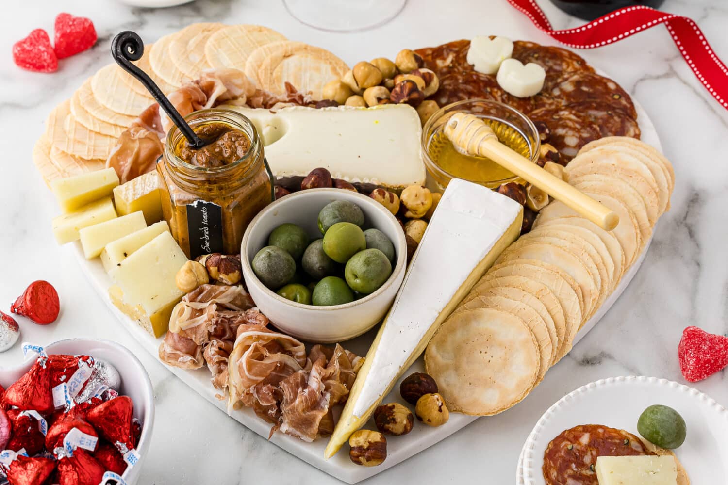 Heart shaped appetizer tray full of meats and cheeses and finger foods
