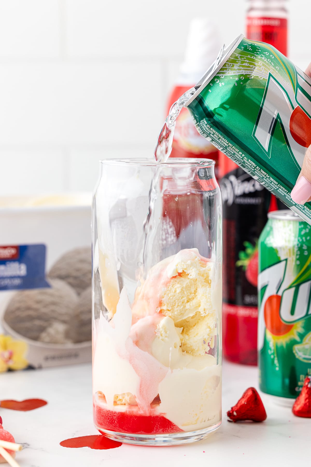 7-up being poured into a glass with ice cream and syrup