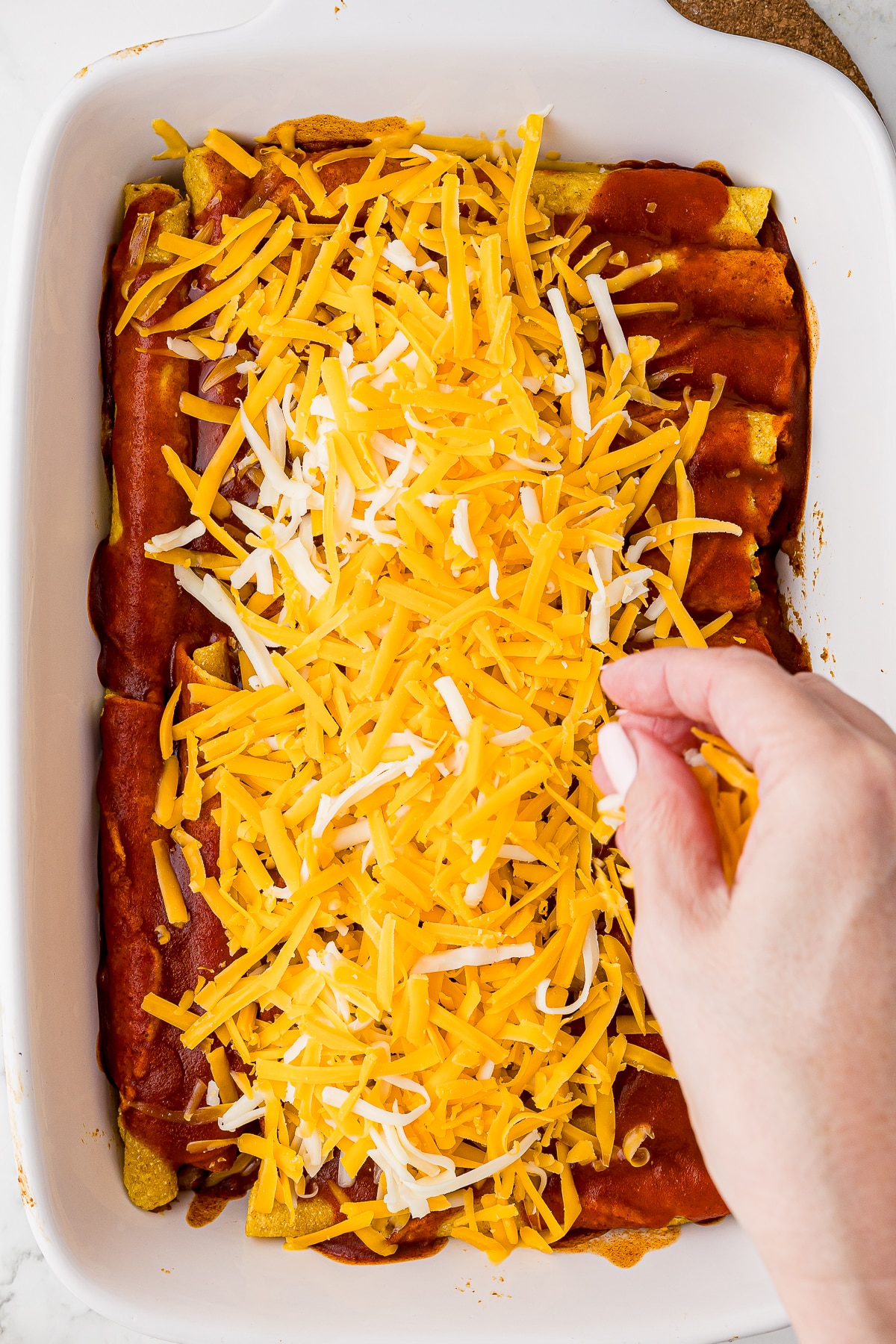shredded cheese over baked taquitos