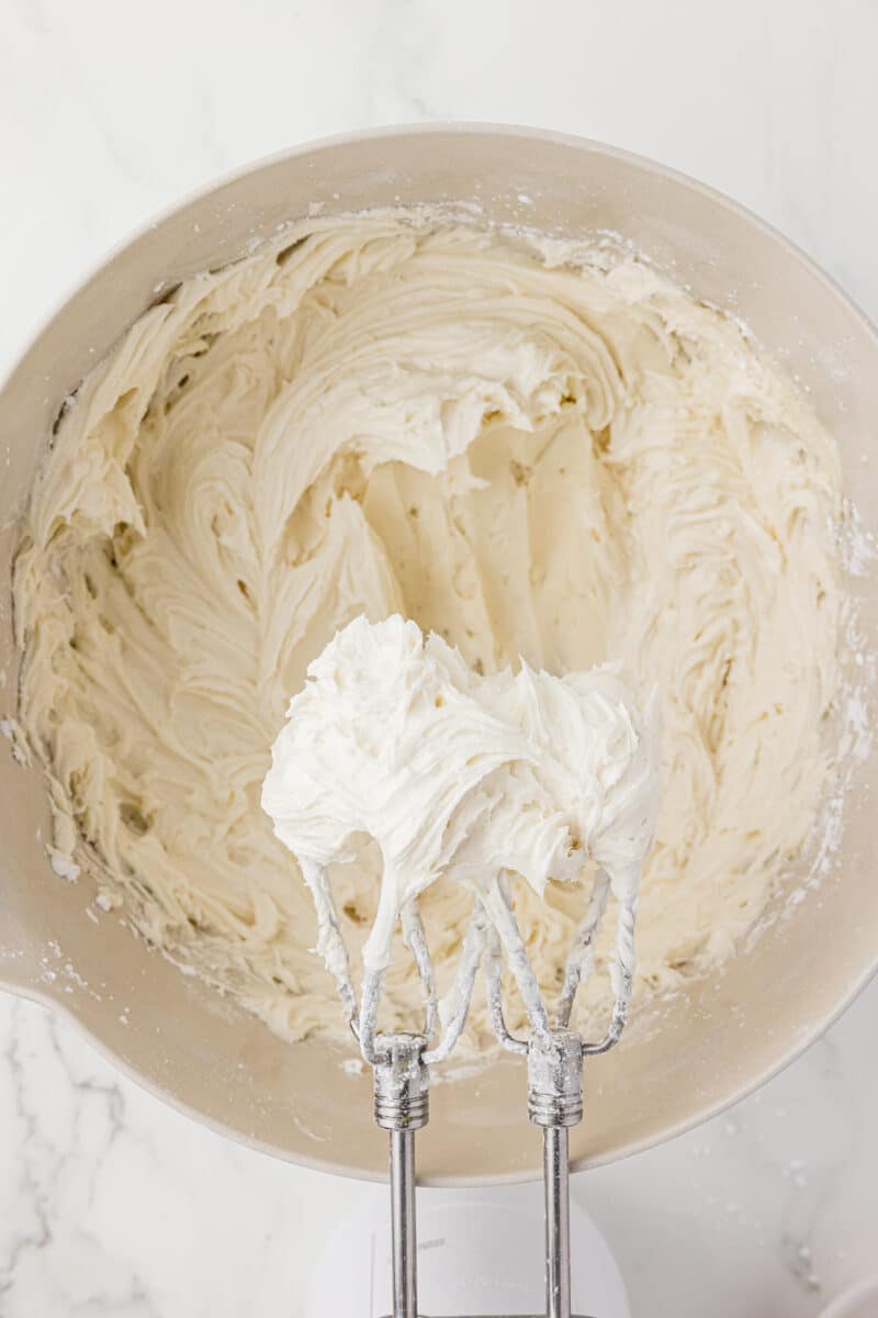 cream cheese on mixer blades over batter bowl