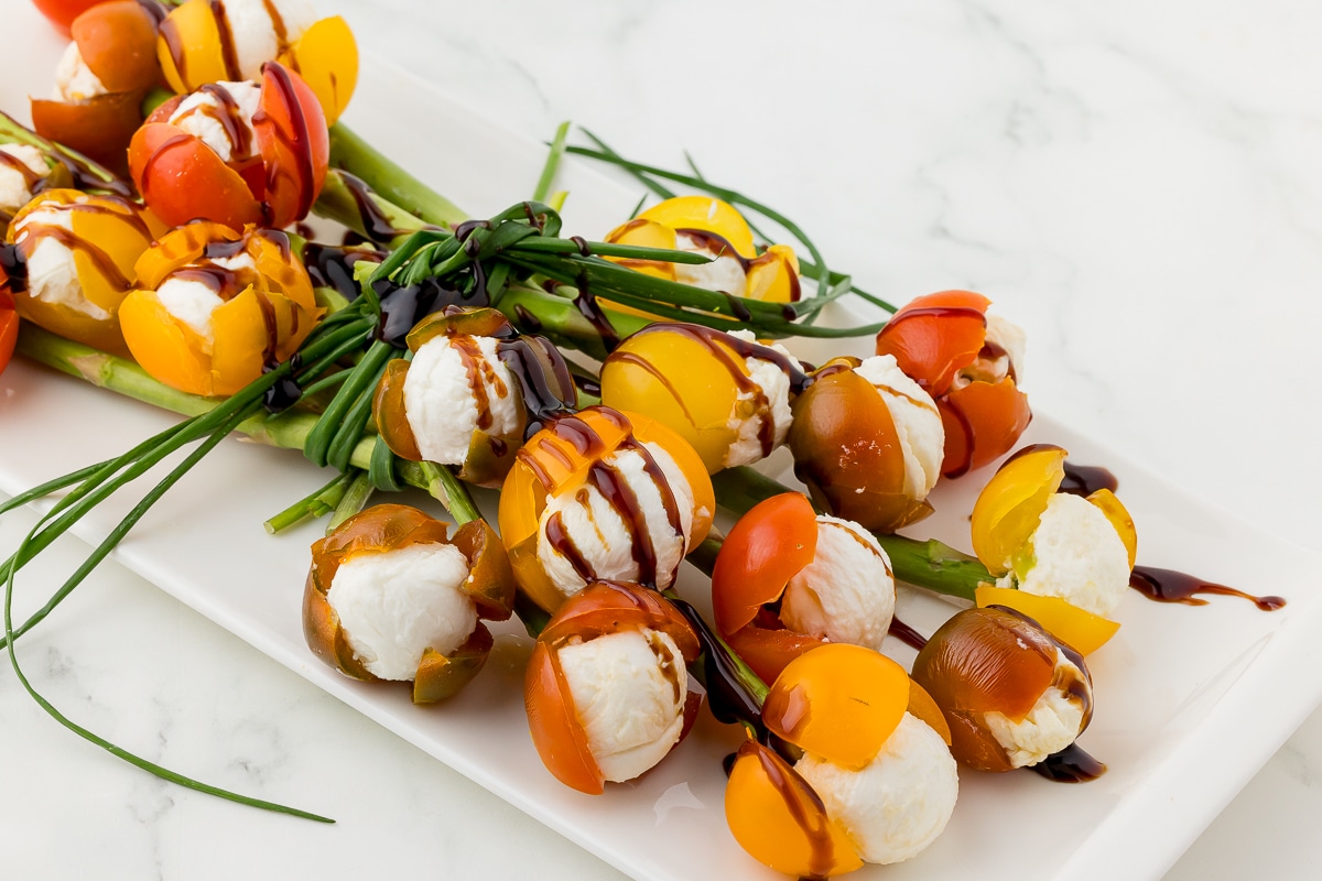 bouquet of cherry tomato tulips filled with mozzarella on a white platter