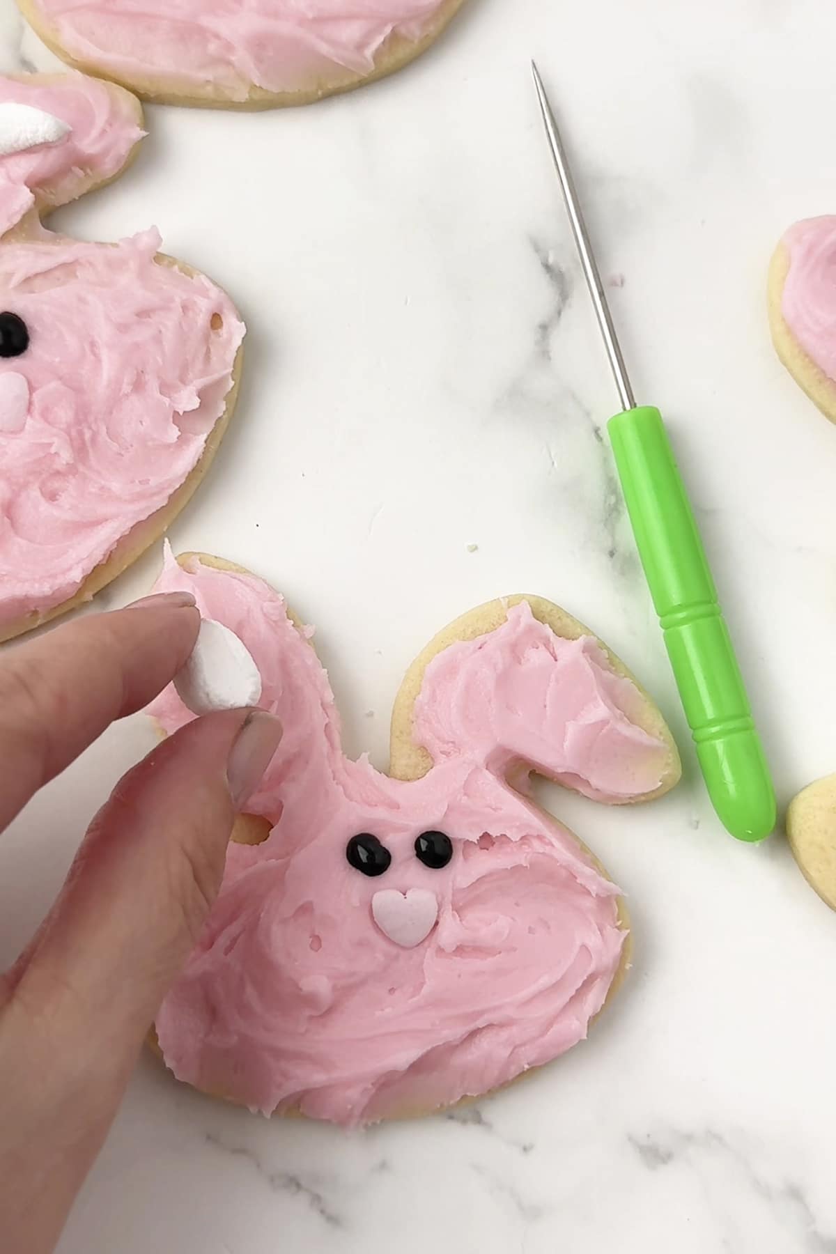 Decorating bunny ears of Easter sugar cookies