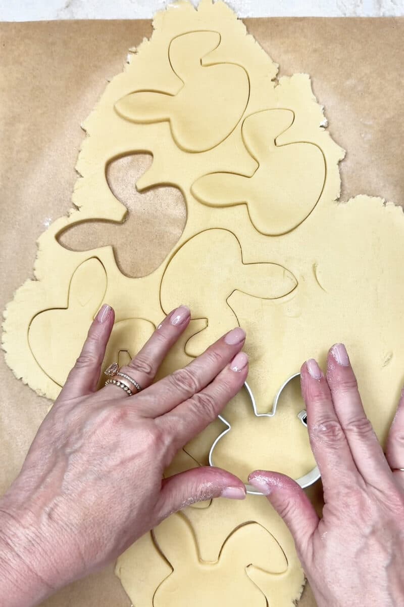Cutting about bunny shaped sugar cookies from the rolled out dough