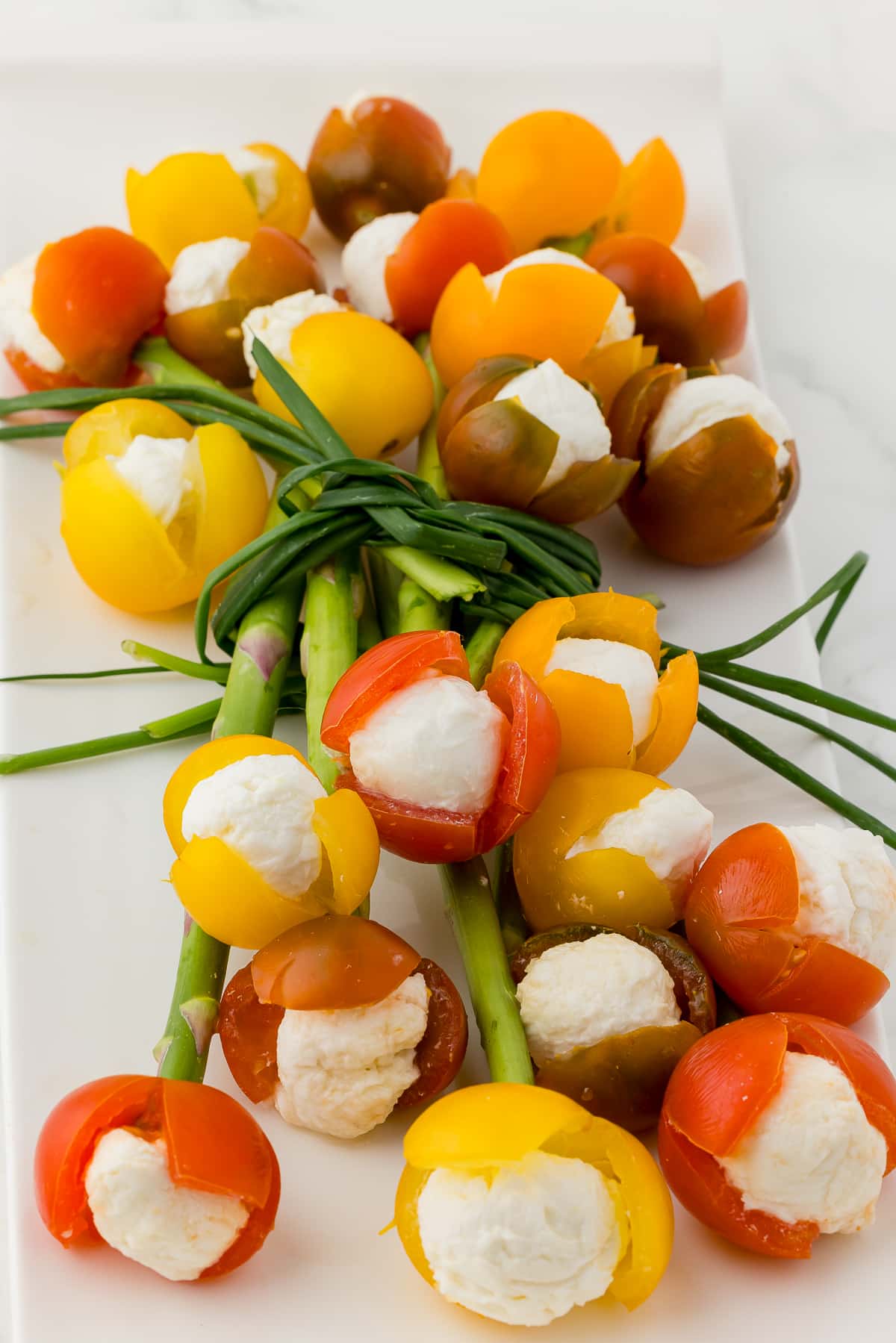 bouquet of cherry tomato tulips filled with mozzarella on a white platter