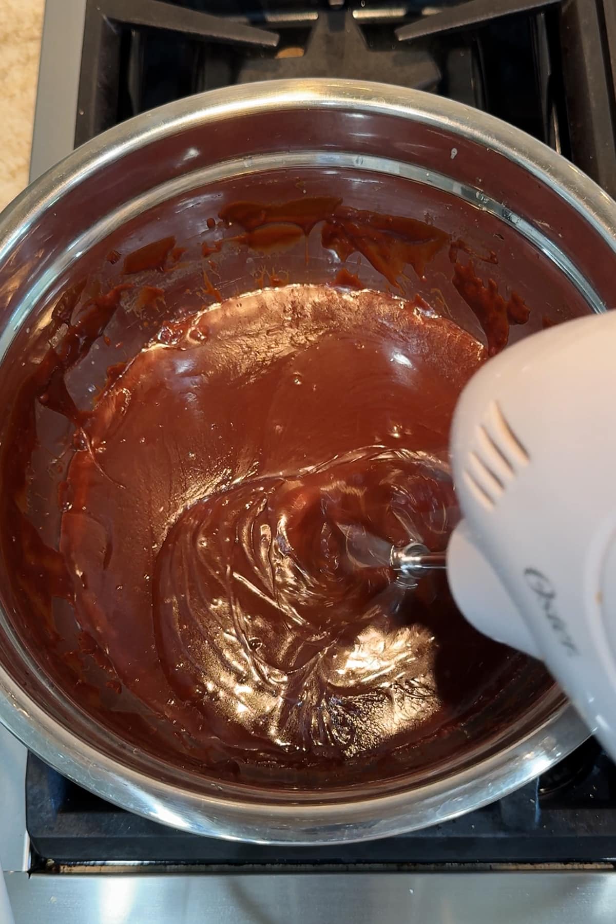 whipping chocolate sauce with an Oster hand mixer