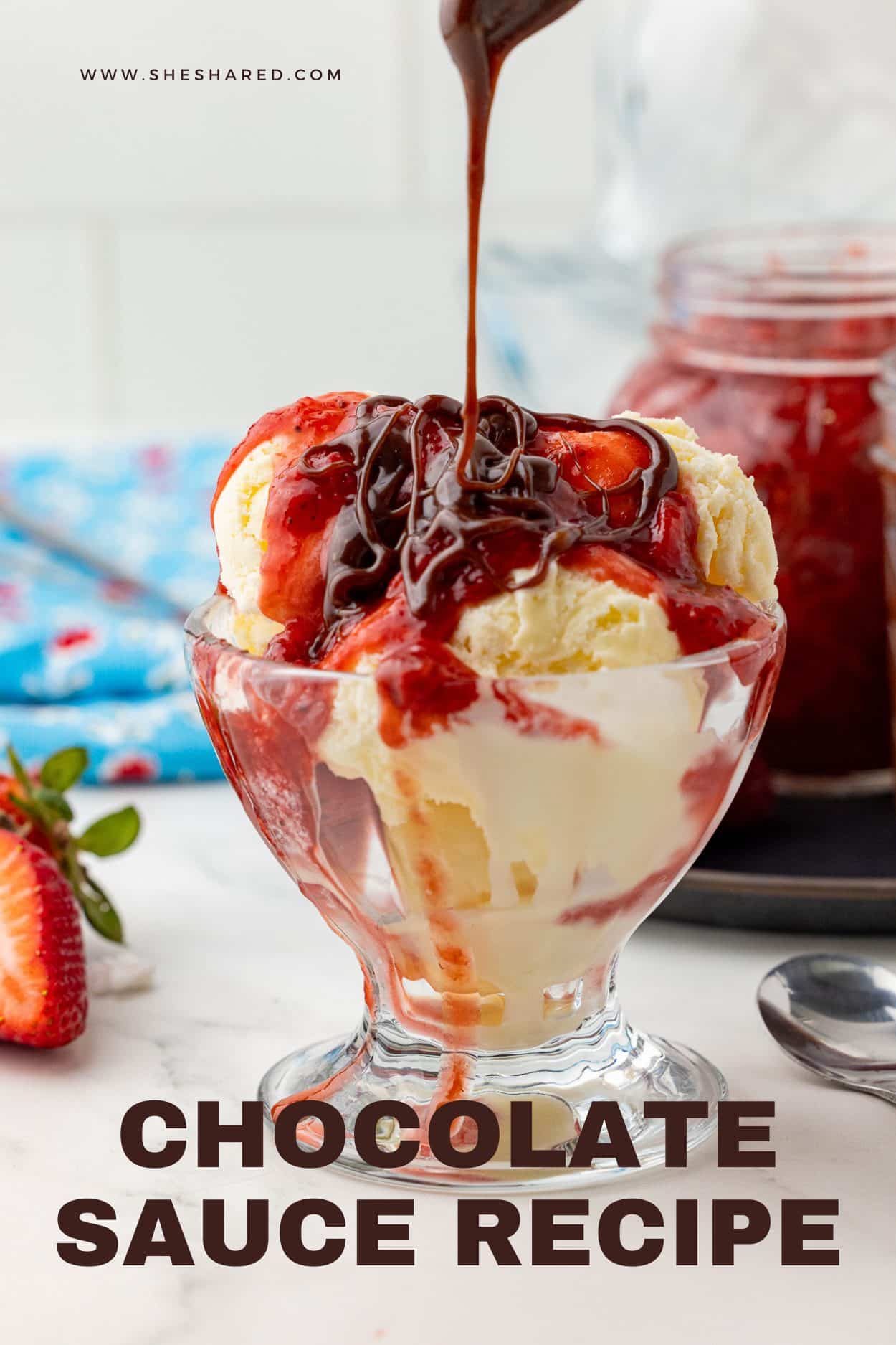 ice cream in a sundae cup topped with strawberry compote and chocolate sauce, with a blue napkin in the background