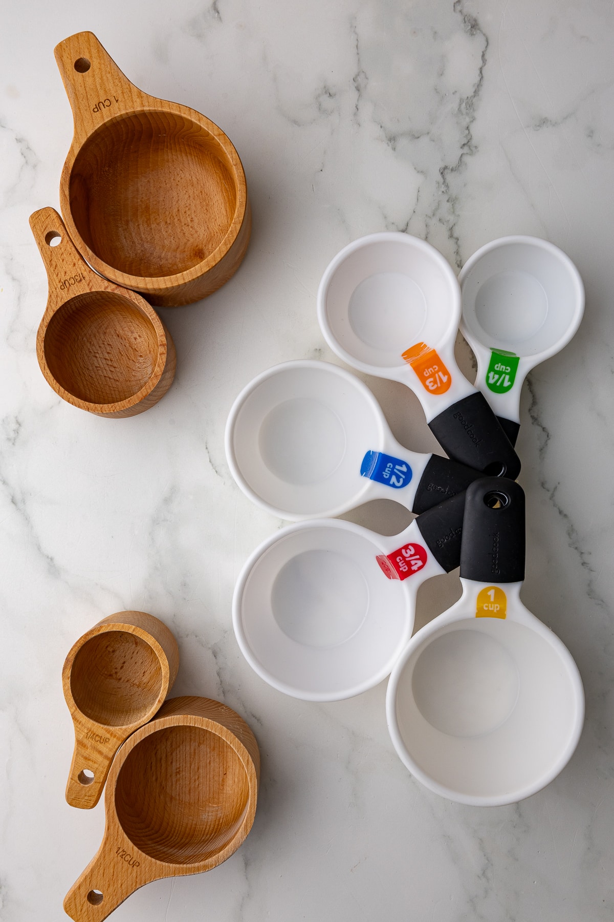 various dry measuring cups on a white marble countertop