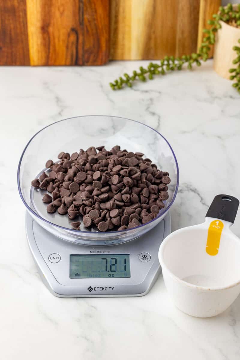 one cup of chocolate chips being weighed on an etekcity kitchen scale on a white countertop