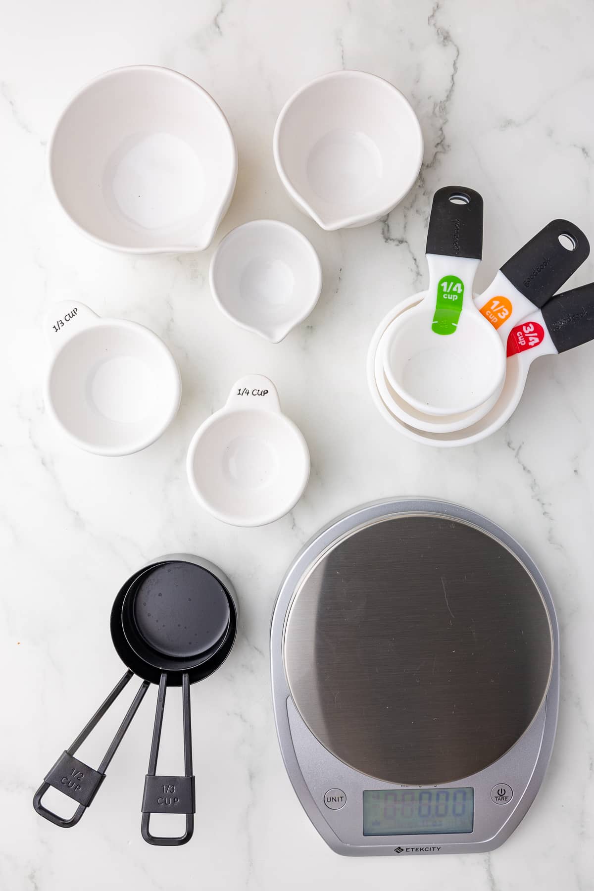 dry measuring cups and a kitchen scale on a white countertop