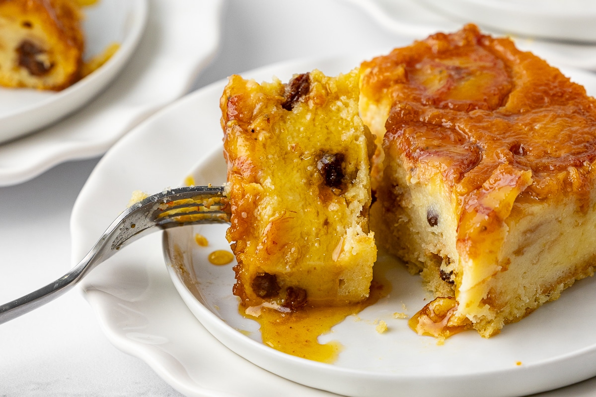 closeup of bread pudding on a dessert plate with a fork
