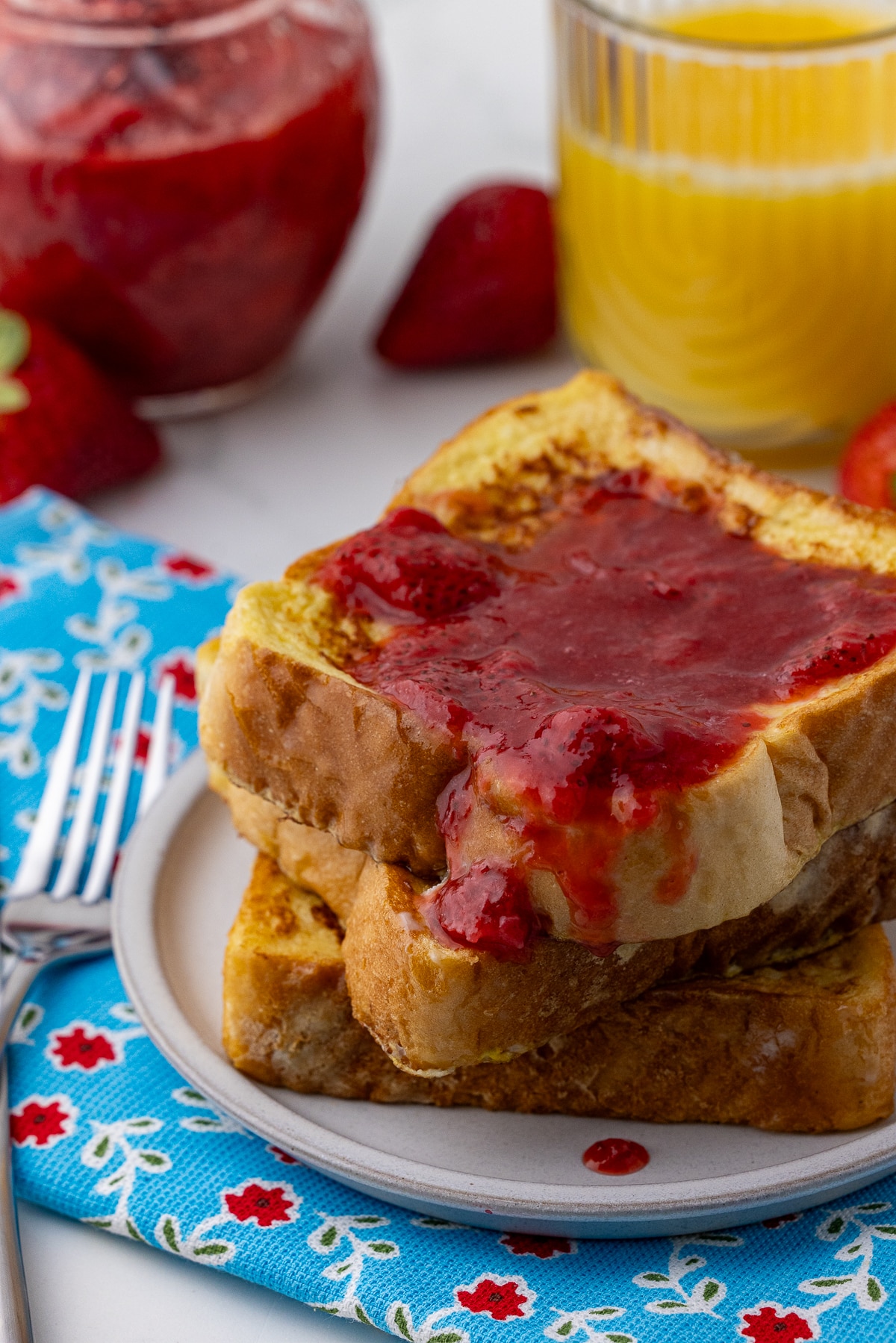 texas toast french toast with strawberry compote and a glass of orange juice in a Better Homes and Gardens glass