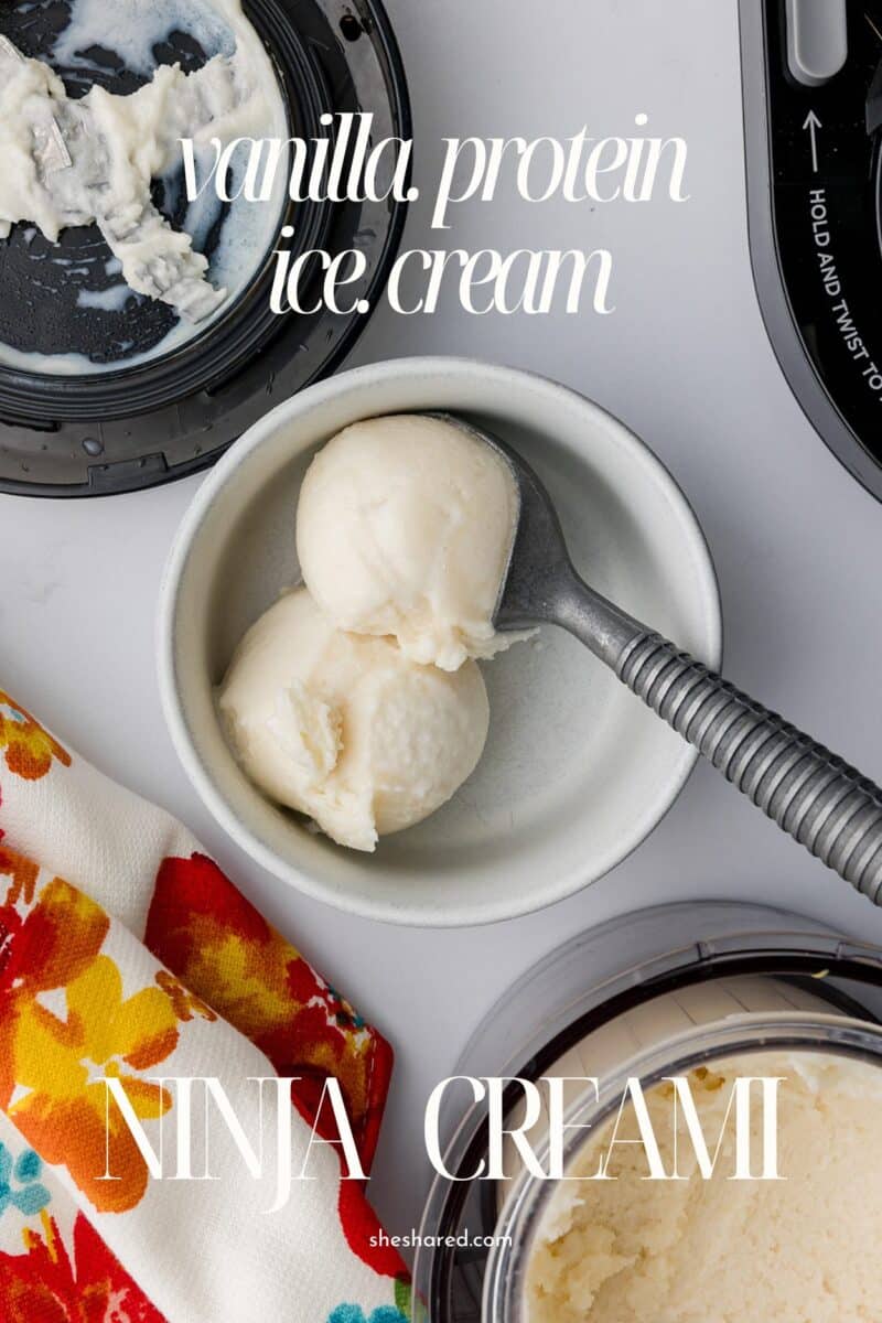 two scoops of vanilla protien ice cream in a white bowl with an ice cream scoop, the blade of the ninja creami ice cream maker and a colorful tea towel