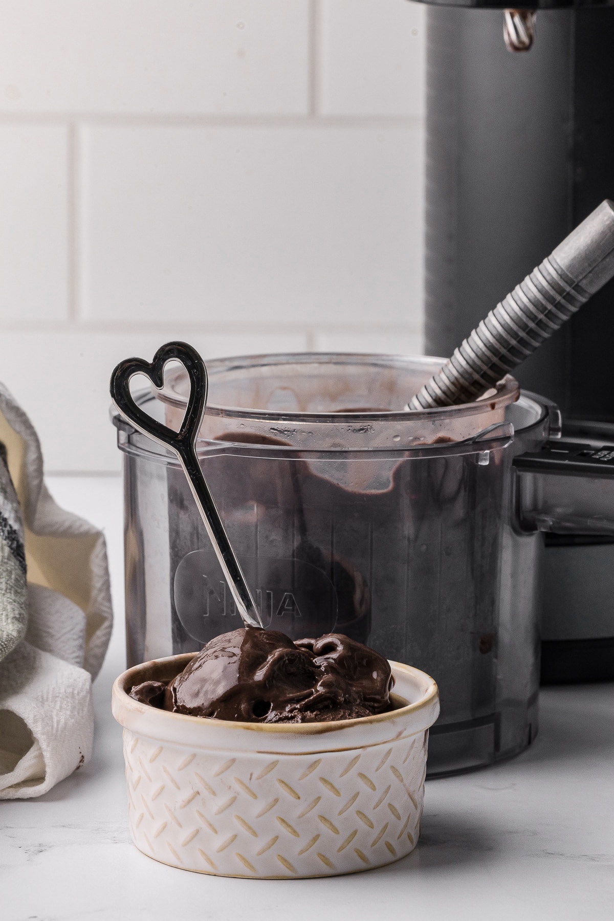 dark chocolate in a bowl with a heart spoon