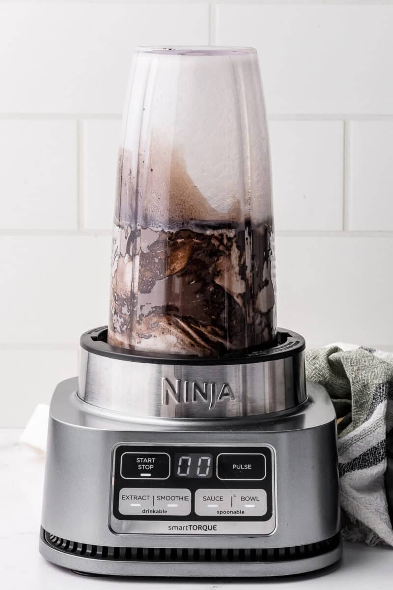 ninja blender with dark chocolate ice cream mixture inside being mixed