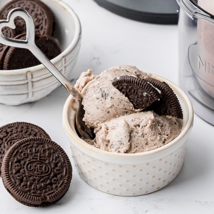 cookies and cream ice cream in a polka dot ramekin with a heart spoon and oreo cookies