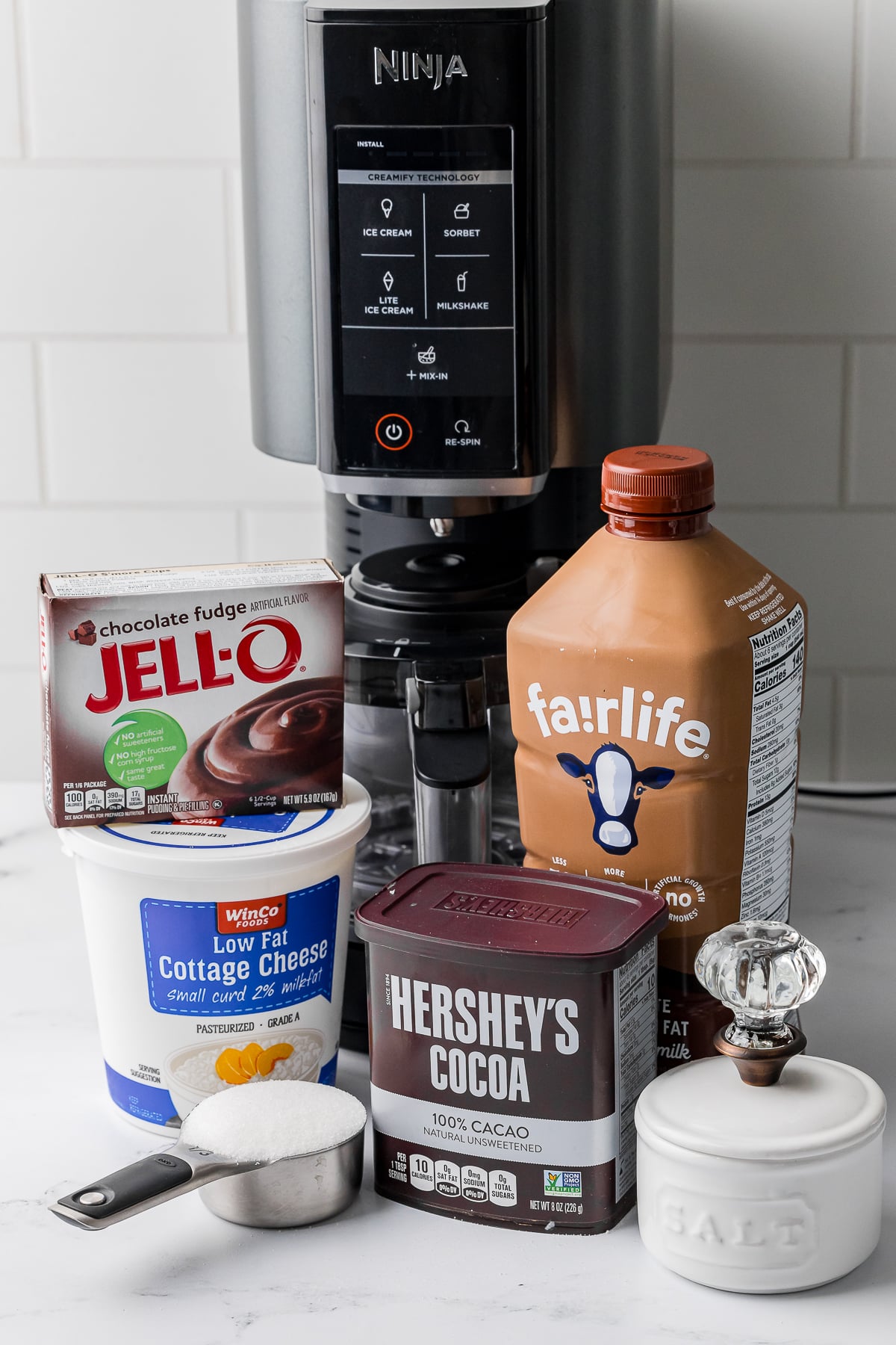 ingredients for the ninja creami chocolate ice cream, fairlife chocolate milk, salt, hershey's cocoa, sugar, cottage cheese, chocolate fudge jello