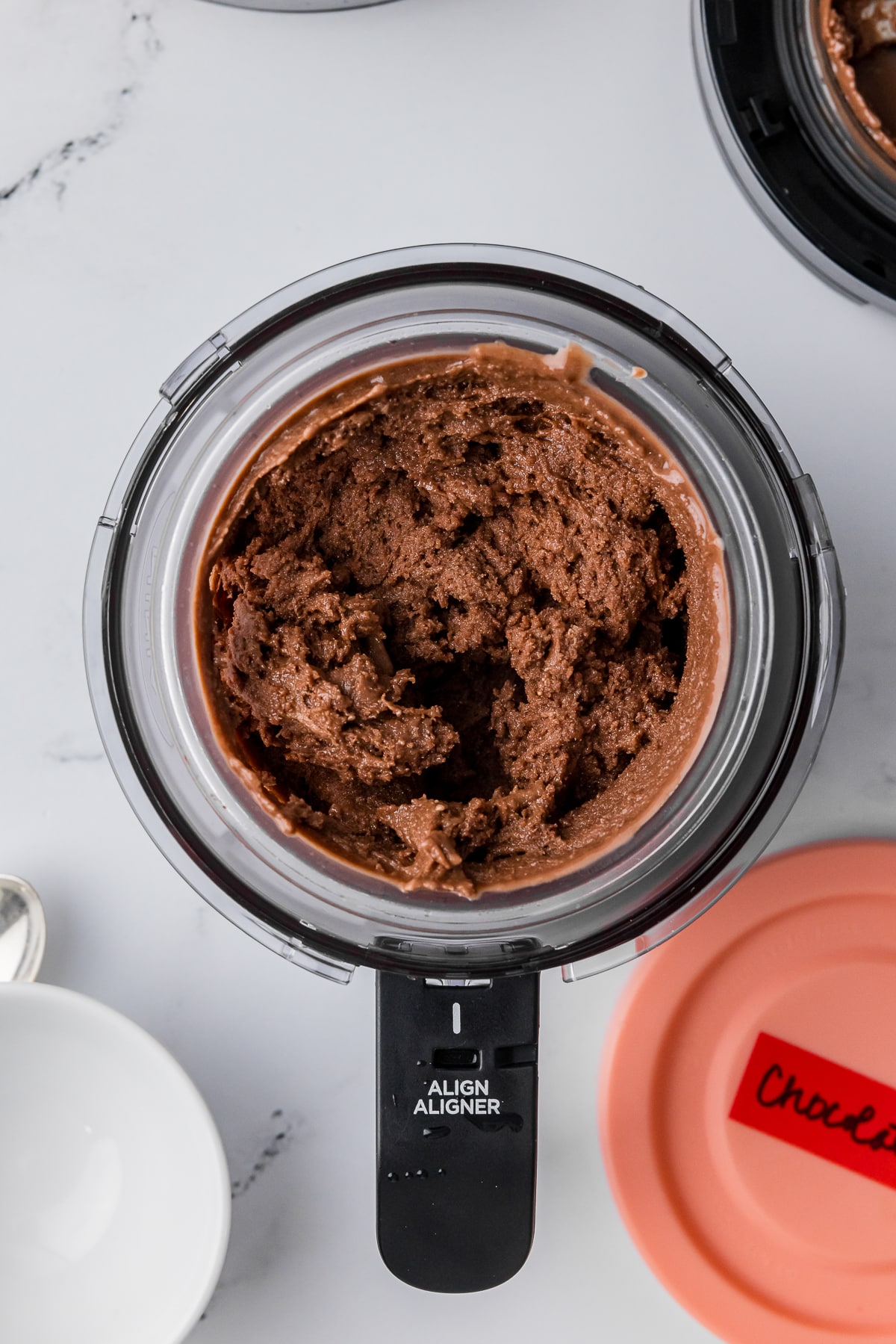 spun chocolate ice cream in a ninja creami pint jar on a white countertop