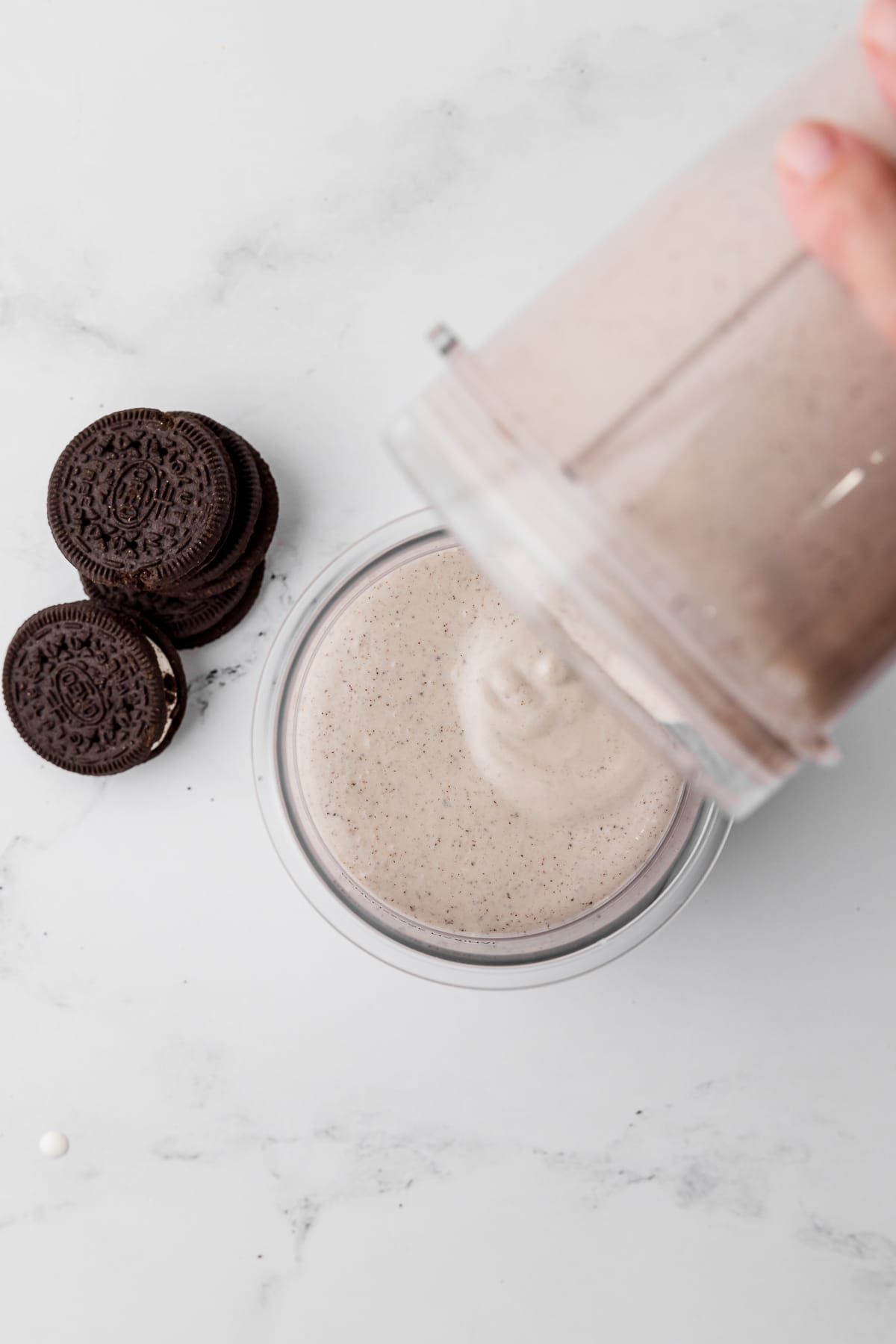 pouring cookies and cream mixture into ninja creami pint jar