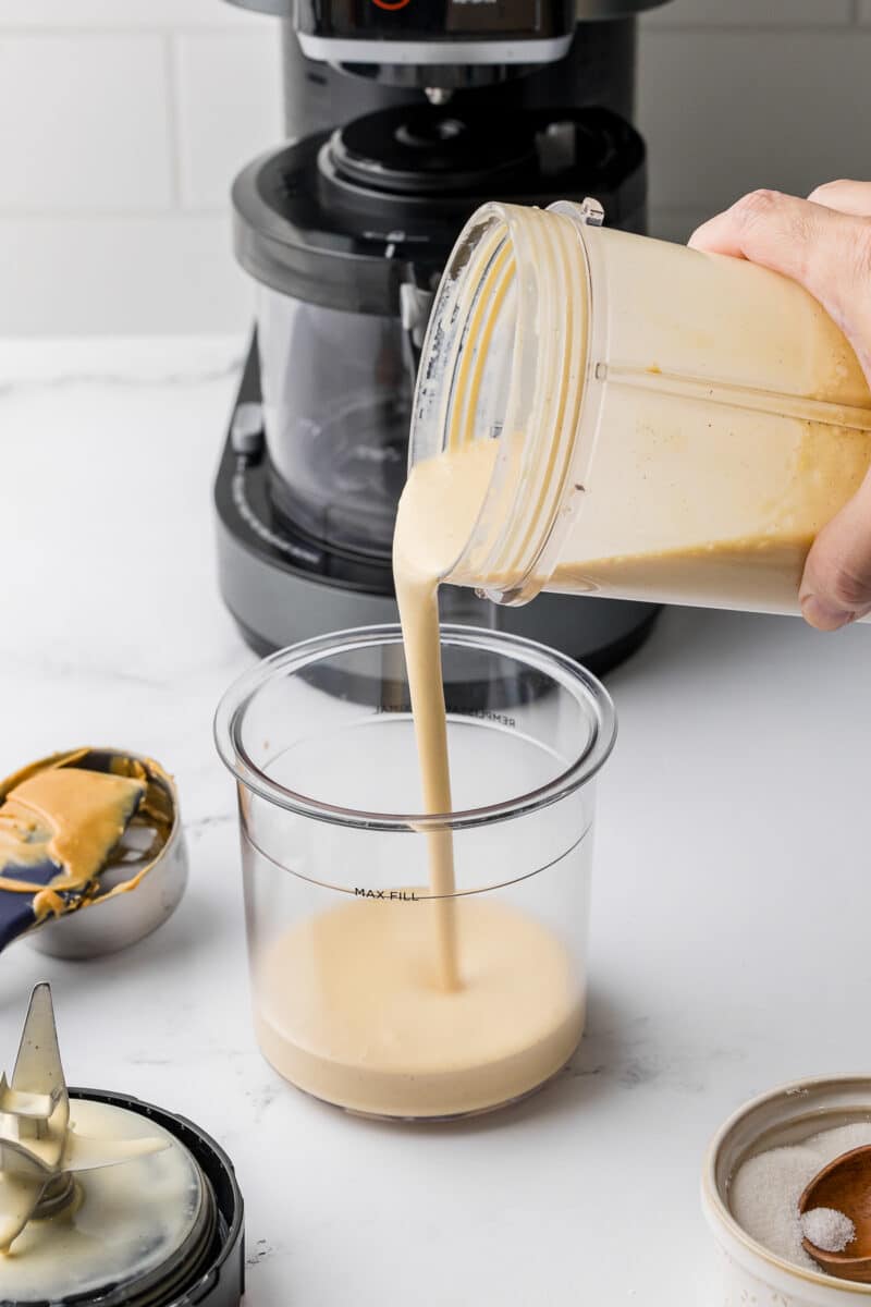 pouring peanut butter ice cream mixture into a ninja creami pint jar