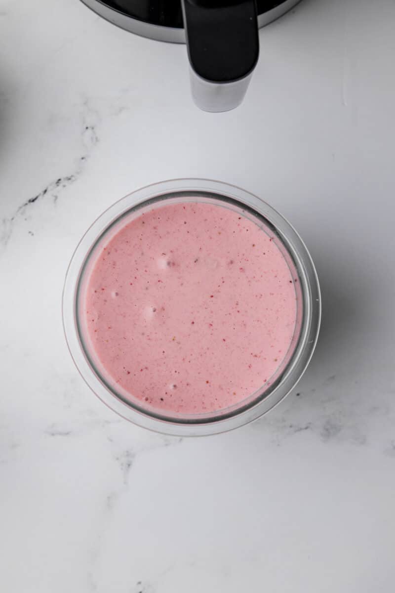 overhead photo of a ninja creami pint jar filled with strawberry banana ice cream mixture