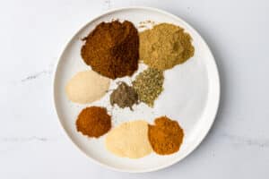 overhead photos of individual spices on a white plate