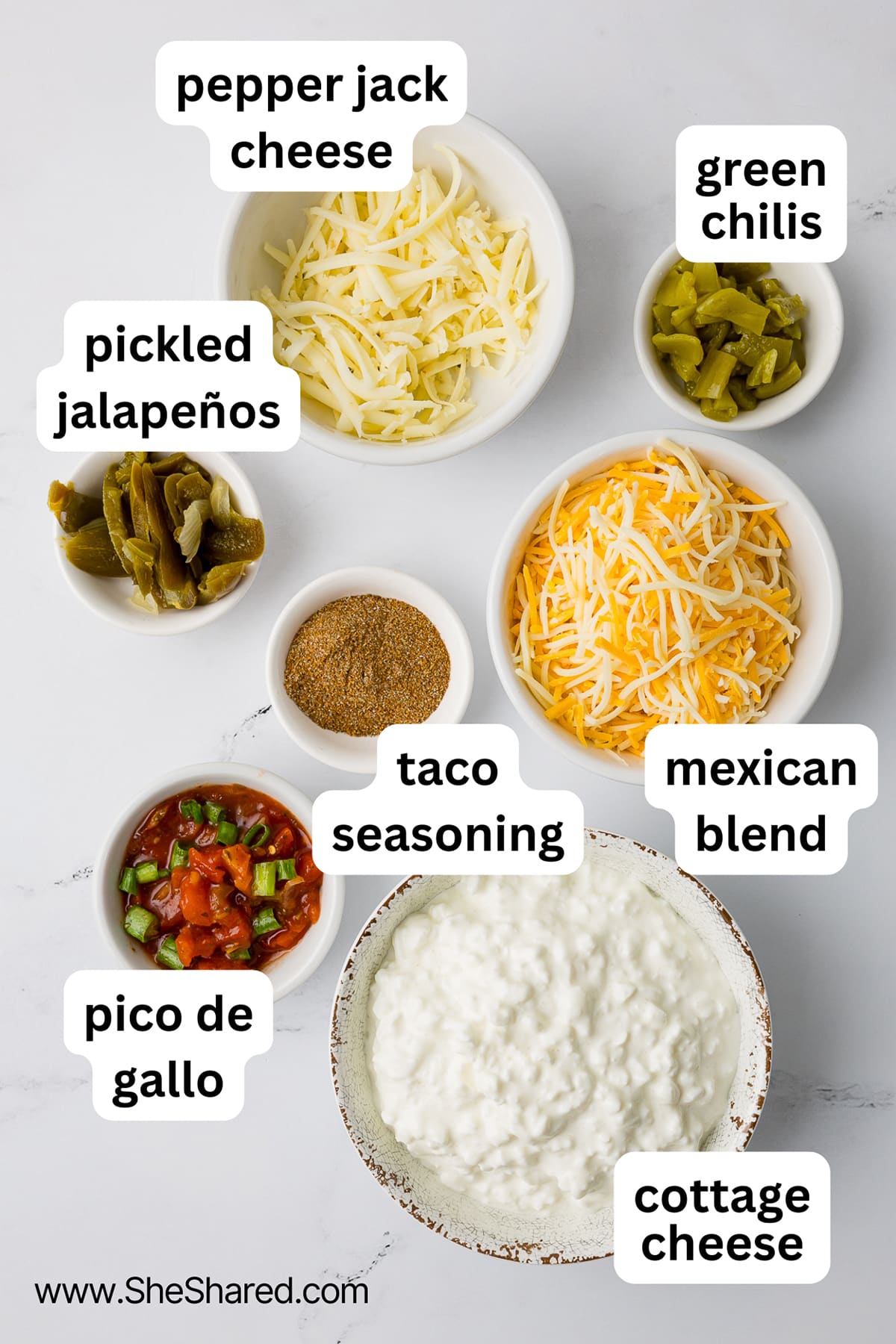 ingredients for cottage cheese queso including pepper jack cheese, green chilis, pickled jalapenos, taco seasoning, mexican blend cheese, pico de gallo, and cottage cheese