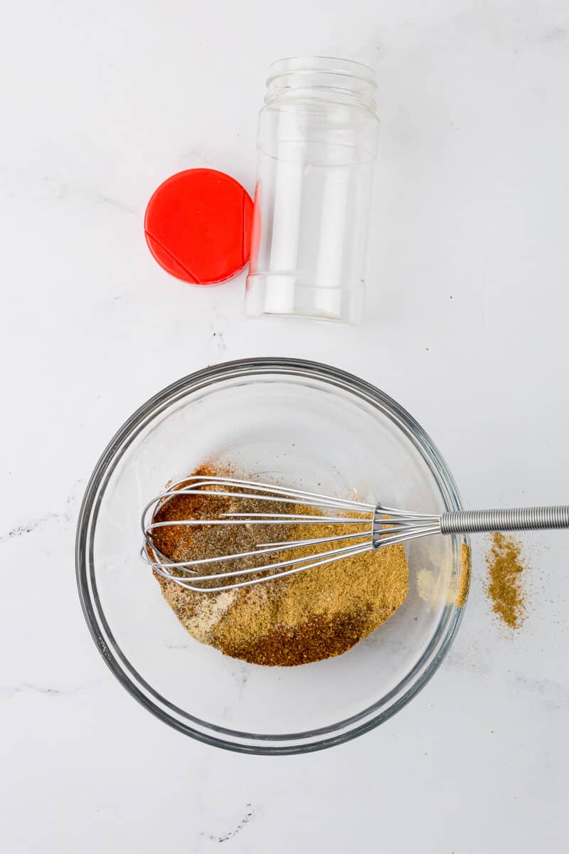 dry taco seasoning in a glass bowl on a white countertop