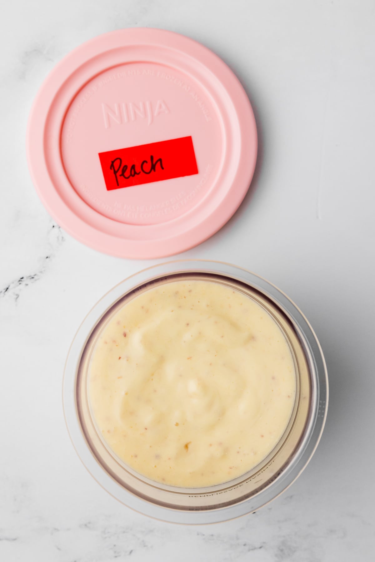 peach ice cream in a ninja creami pint jar