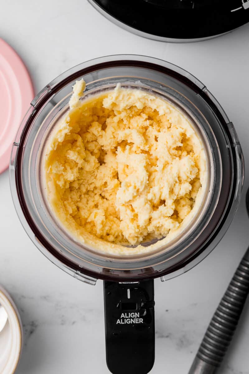 mixed peach ice cream in the ninja creami pint jar that is in the ninja creami bowl