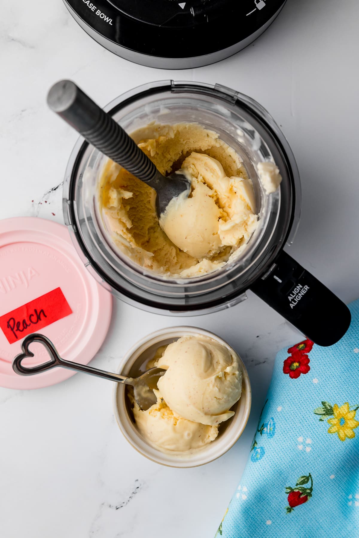 overhead shot of ninja creami peach ice cream in the bowl of the creami